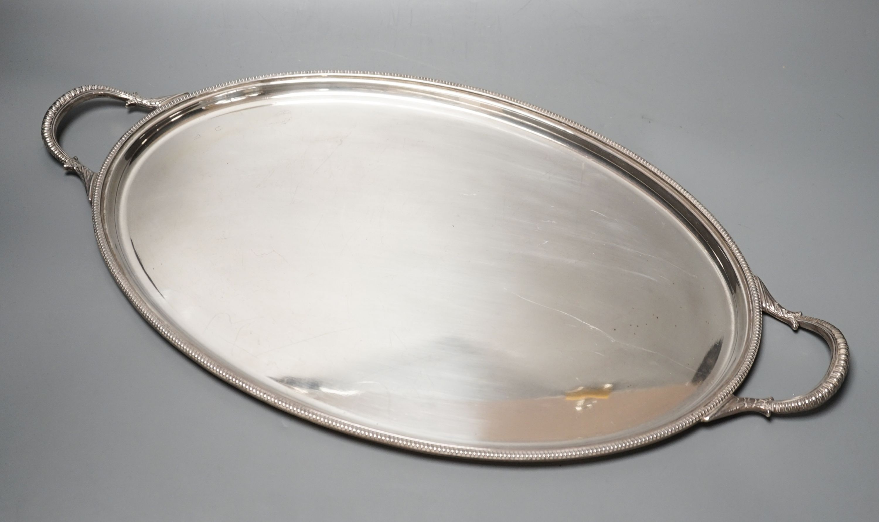 A mid 20th century silver two handled oval tea tray by Roberts & Belk, 56.3cm over handles, 57oz.